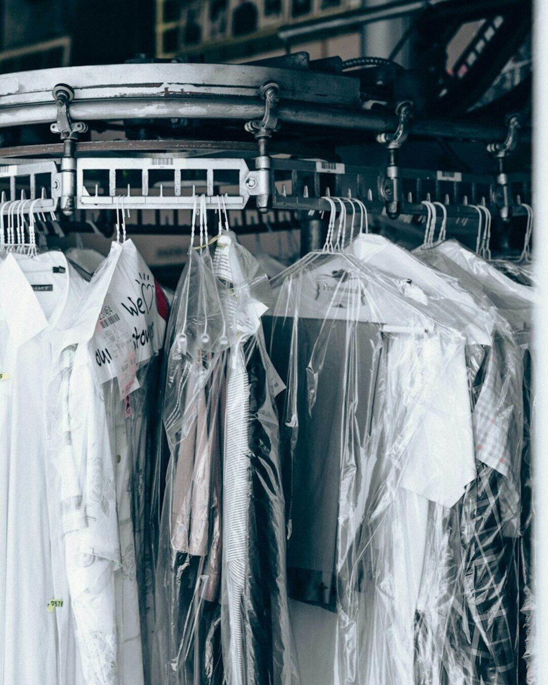 Freshly cleaned garments in protective dry-cleaning bags on a rack at Orellana Cleaners in Sanford, NC